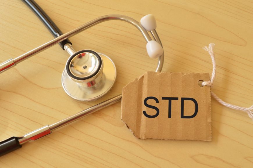 Stethoscope and label tag written with STD stands for SEXUALLY TRANSMITTED DISEASES